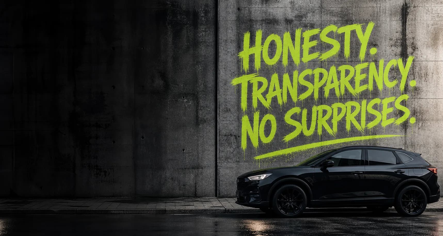 Concrete wall with lime green Honesty, Transparency, No Surprises graffiti and a premium black rental vehicle